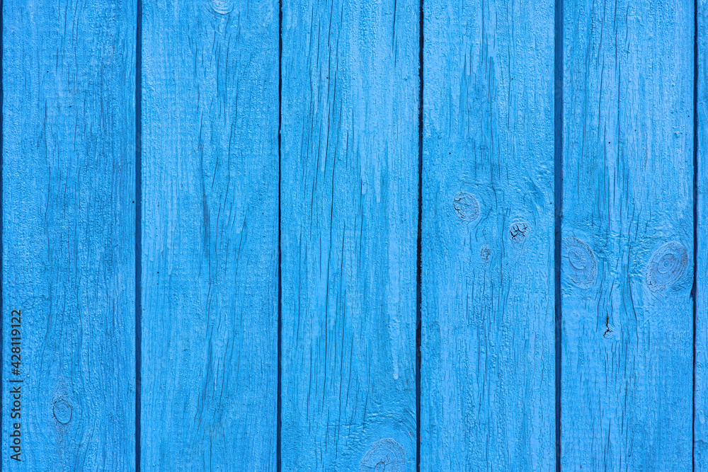 Fototapeta premium Old blue wooden wall of a house with cracked oil paint. Bright colorful vintage wood background