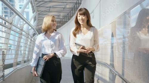 Happy smiling young business women are working in modern city, talking about business plan