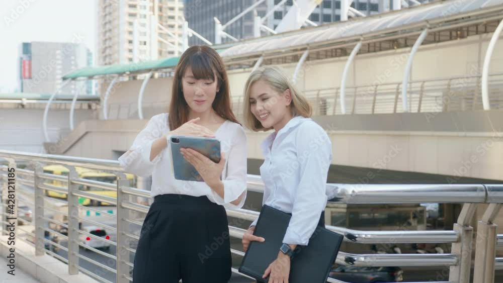 Happy smiling young business women are working in modern city, talking about business plan