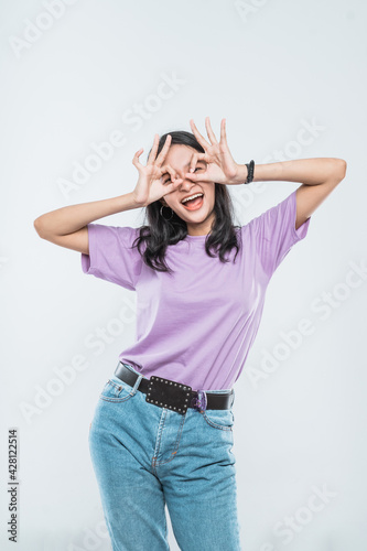 Beautiful young Asian woman smiling happy show OK sign over her eye on white background