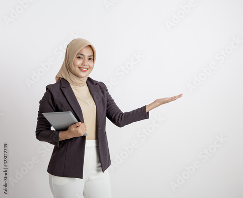 woman entrepreneur wearing hijab smiling with holding tablet showing copy space, formal work concept solated white background photo