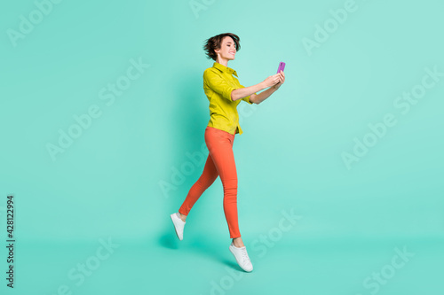 Full length body size photo of female blogger taking selfie usinf smartphone isolated vivid turquoise color background