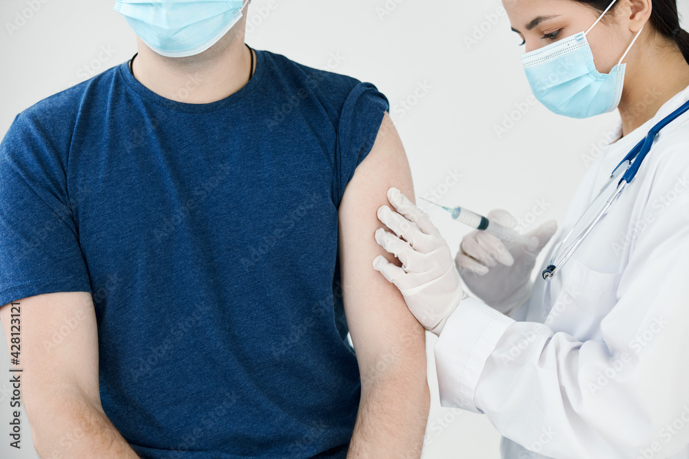 beautiful woman doctor in medical mask giving an injection to a patient covid vaccination beautiful woman doctor in medical mask giving an injection to a patient covid vaccination