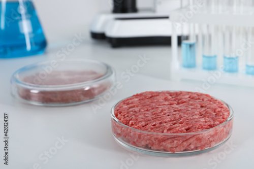 Petri dish with raw minced cultured meat on white table in laboratory, space for text