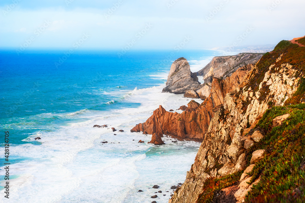 Cliffs on the shore of Atlantic ocean in Cabo da Roca (Cape Roca) in Portugal. Westernmost point of continental Europe. Summer landscape