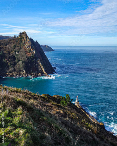 San Sebastian, Spain - March 1, 2021: Puntas Lighthouse and the rugged coastline at the mouth of the Rio Oyarzun in Pasajes photo