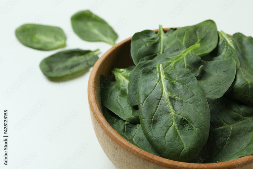 Bowl of spinach leaves on white background Bowl of spinach leaves on white background