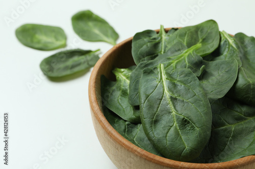 Bowl of spinach leaves on white background