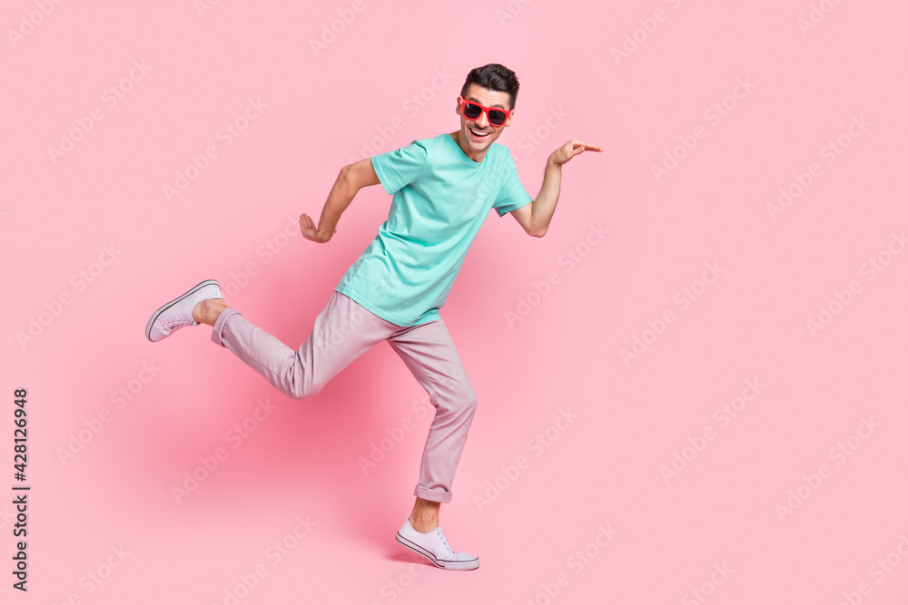 Full size profile side photo of young excited man happy smile have fun posing comic isolated over pastel color background Full size profile side photo of young excited man happy smile have fun posing comic isolated over pastel color background