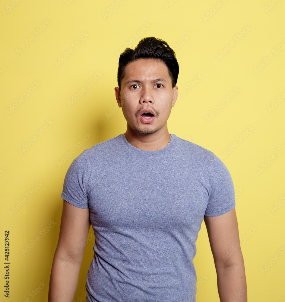 man wearing casual t-shirt talk expression looking the camera isolated on a yellow color background man wearing casual t-shirt talk expression looking the camera isolated on a yellow color background