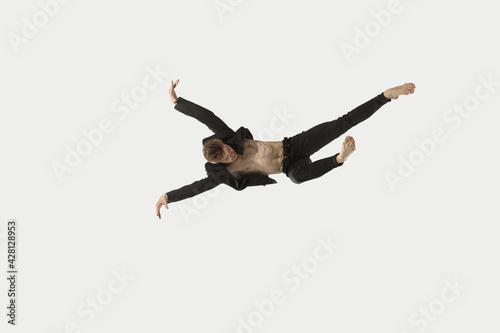 Man in casual style clothes jumping and dancing isolated on white background. Art, motion, action, flexibility, inspiration concept. Flexible caucasian ballet dancer.