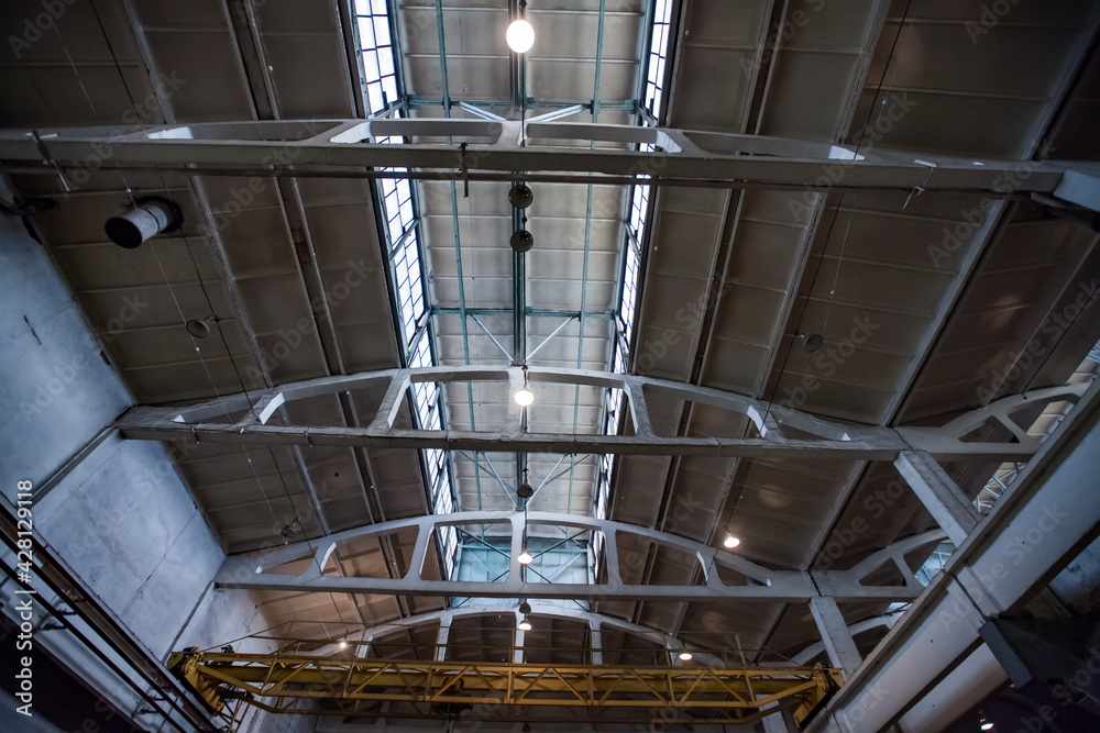View on industrial building ceiling and roof. Concrete girders. Train car-building plant workshop. View on industrial building ceiling and roof. Concrete girders. Train car-building plant workshop.