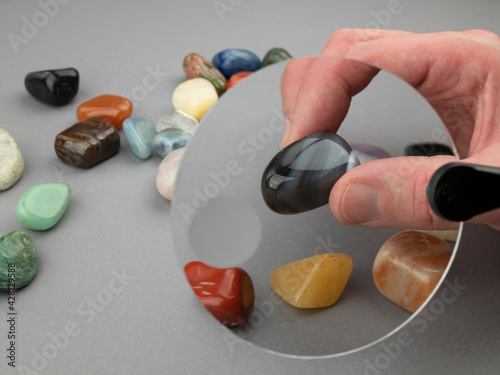 Exploring semi-precious stones with a loupe. Colored gemstones under the magnifying glass photo