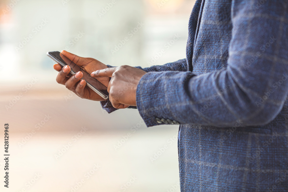 Closeup shot of an unrecognizable businessman using a cellphone in the city. Staying connected in this digital age. 