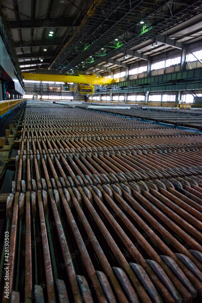 Naklejka premium Copper metallurgical plant. Electro-refining electrolysis workshop. Copper anode plates in sulfuric acid bath. Background is blurred.