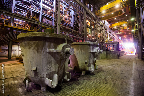 Copper metallurgical plant. Metallurgical buckets in factory workshop. Focus on left metallurgical bucket. photo