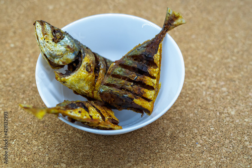 Fried fish, or ikan goreng. Indian Mackerels, or Rastrelliger spp. Also called Ikan Banyar or Ikan Kembung in Indonesia. Fried dry with turmeric seasoning. photo