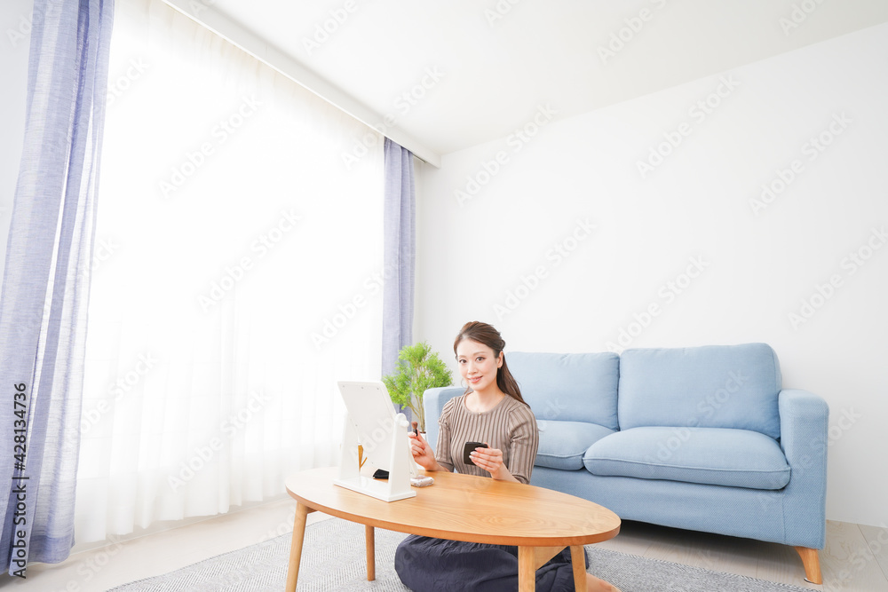 一人暮らしの部屋で化粧をする女性 一人暮らしの部屋で化粧をする女性