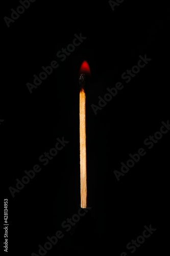 One burning match on a completely black background