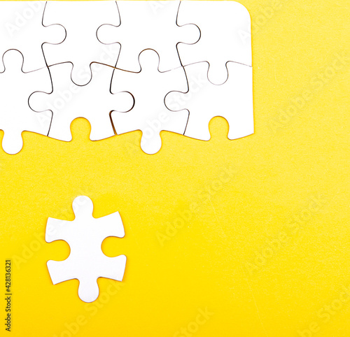 white jigsaw puzzle isolated on a yellow background