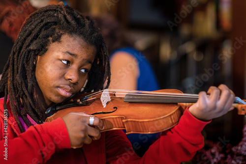 girl practicing and learning violin play at home
 photo