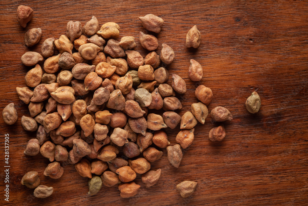macro Close-up of Organic chana or chickpea (Cicer arietinum) or whole white Bengal gram dal cleaned on wooden top background. macro Close-up of Organic chana or chickpea (Cicer arietinum) or whole white Bengal gram dal cleaned on wooden top background.