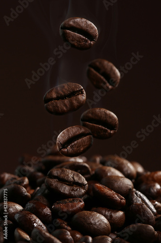 Falling coffee beans in hot steam close-up
