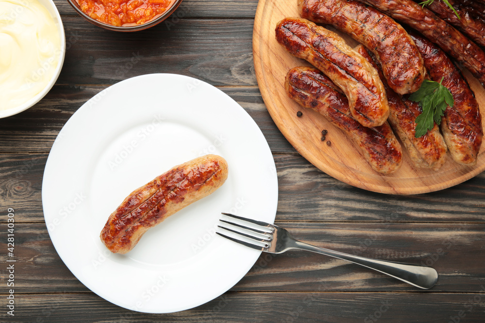 Grilled sausage on plate on brown background