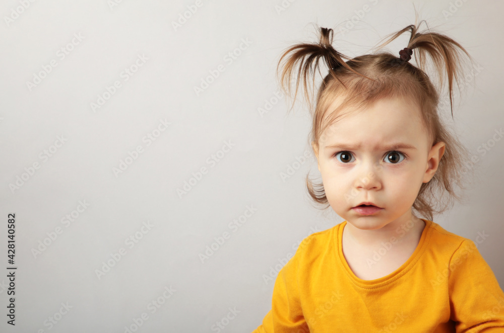 Naklejka premium Portrait of angry little girl on blue background with copy space