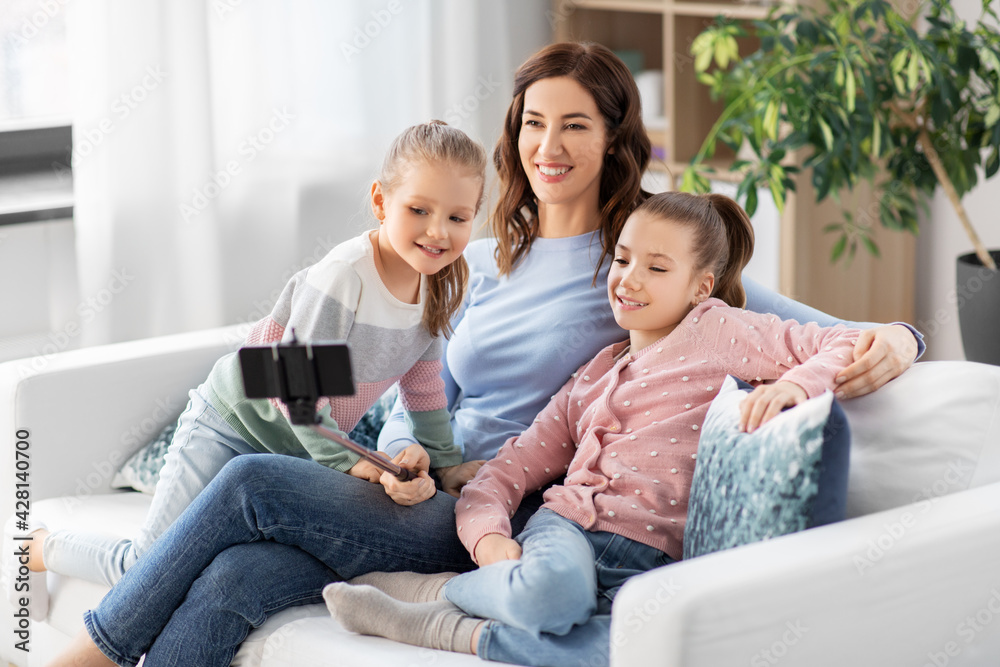 family, technology and people concept - happy mother and daughter with smartphone taking selfie at home family, technology and people concept - happy mother and daughter with smartphone taking selfie at home