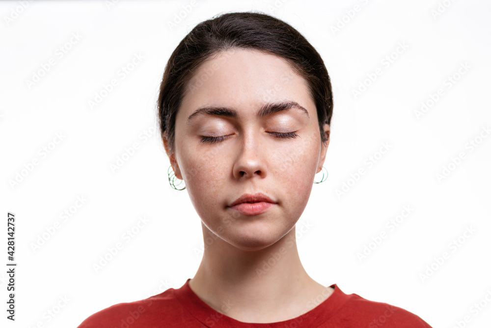 Portrait of a young woman in close-up,with her eyes closed. White background. Copy space. The concept of beauty and facial care Portrait of a young woman in close-up,with her eyes closed. White background. Copy space. The concept of beauty and facial care