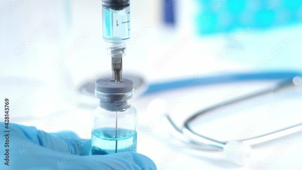 Doctors hands in medical gloves fills syringe with vaccine covid-19. Ampoule with drug. Coronavirus, covid-19, flu. Medical background Doctors hands in medical gloves fills syringe with vaccine covid-19. Ampoule with drug. Coronavirus, covid-19, flu. Medical background