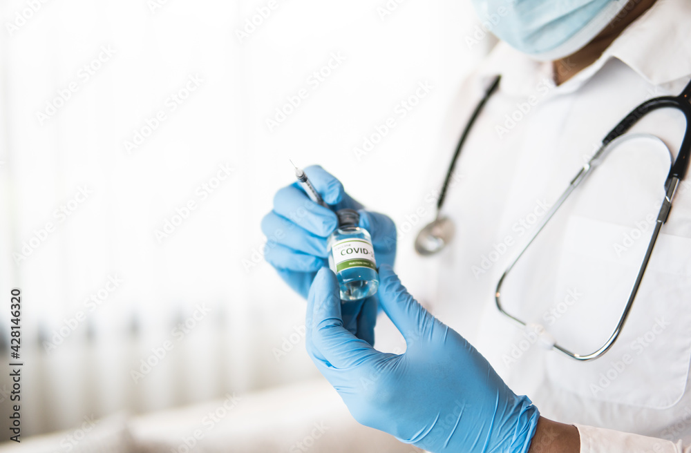 Closeup of doctor holding vaccine and syringe, concept of medical Closeup of doctor holding vaccine and syringe, concept of medical