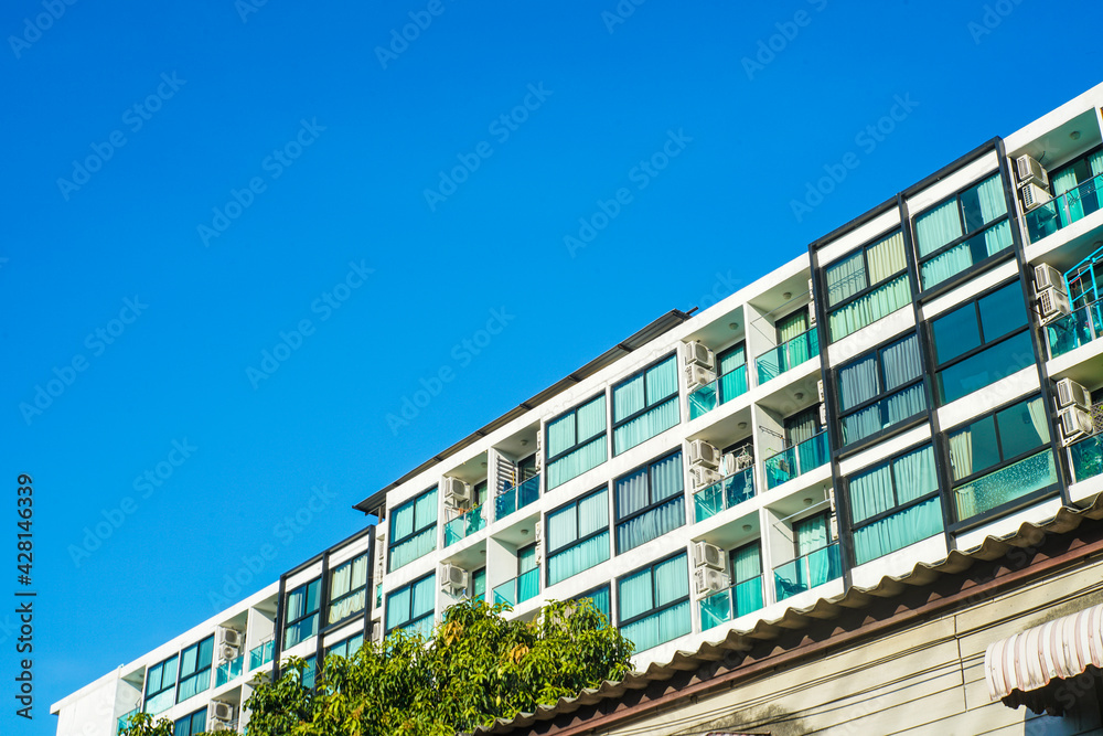 Obraz premium Modern low rise condominium residence against blue sky