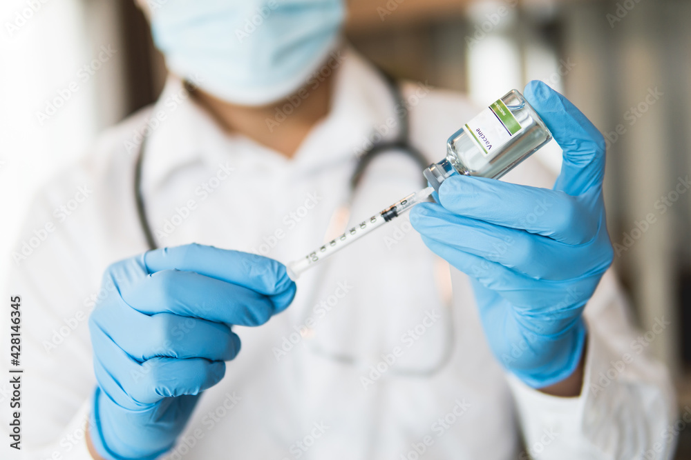 Close up of doctor holding vaccine and syringe, concept of medical for vaccine anti coronavirus, selective focus. Close up of doctor holding vaccine and syringe, concept of medical for vaccine anti coronavirus, selective focus.