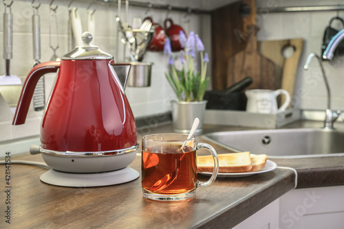 Red electric kettle and cap of tea photo