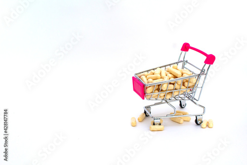 Trolley full of vegeterian pills. Isolated on white background. Drug delivery concept. Copyspace © Tatiana
