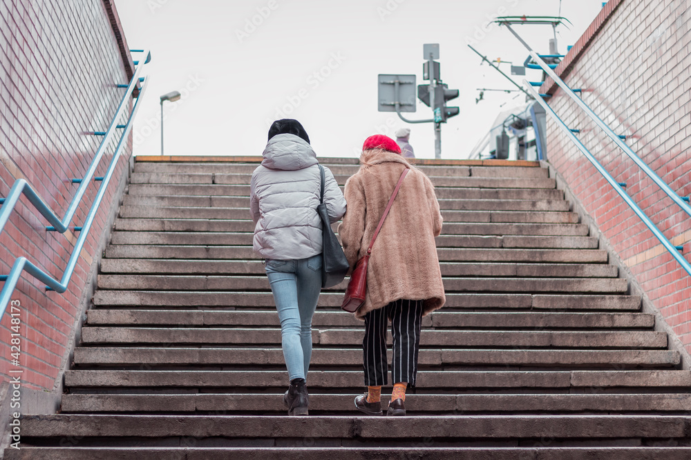 two women climbing up the stairs from underground