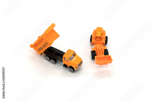 Yellow excavator and truck model toys isolated on white background.