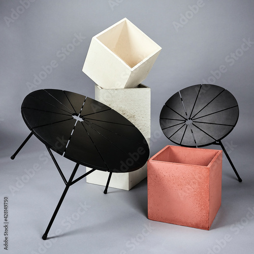Black round wooden table s  with concrete cubes which were shot in studio with flash light on a grey background