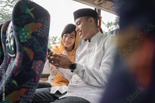 muslim couple travel by bus during eid mubarak holiday to meet family at home
