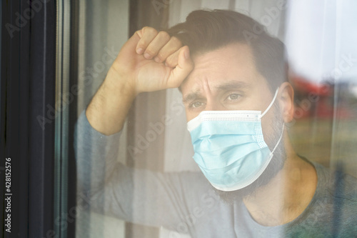 Close up of man on quarantine looking through the window