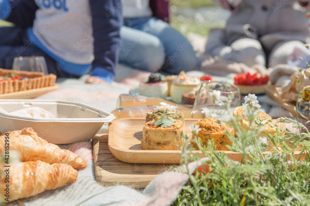 Picnic setting with picnic food, picnic hamper basket, guitar and food ready for party Picnic setting with picnic food, picnic hamper basket, guitar and food ready for party