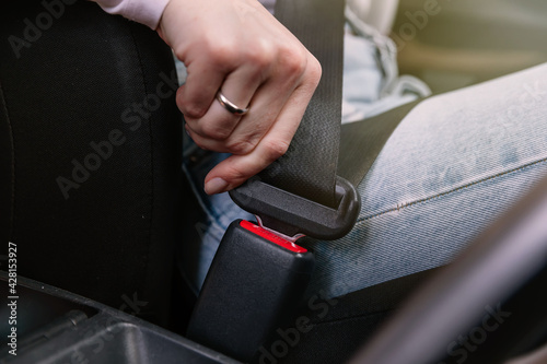 Close up image of business woman sitting in a car putting on her