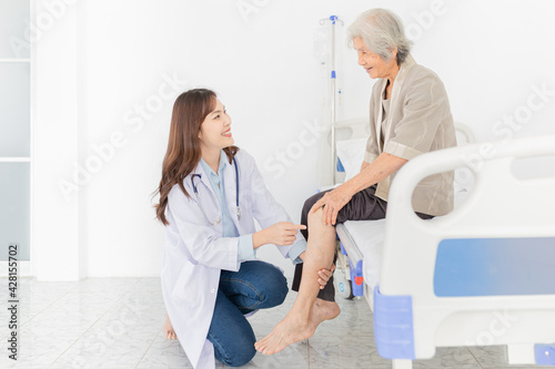 smart asian female doctor holding leg of old stroke patient in hospital  elderly rehabilitation clinic  they training to rehab muscle