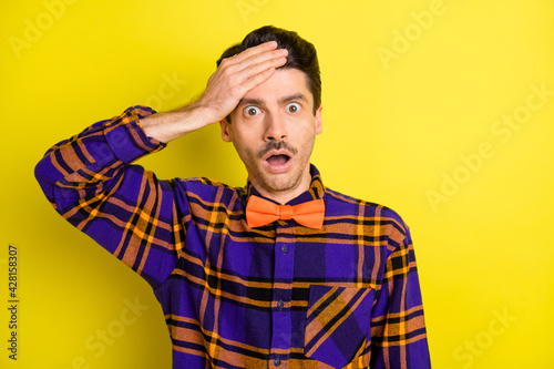 Photo of crazy loser man open mouth palm brow wear bow tie plaid shirt isolated yellow color background © deagreez