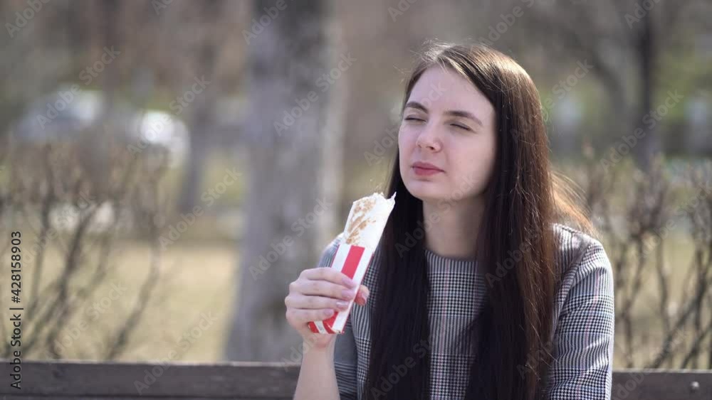 woman with long hair eating doner or shawarma at spring woman with long hair eating doner or shawarma at spring