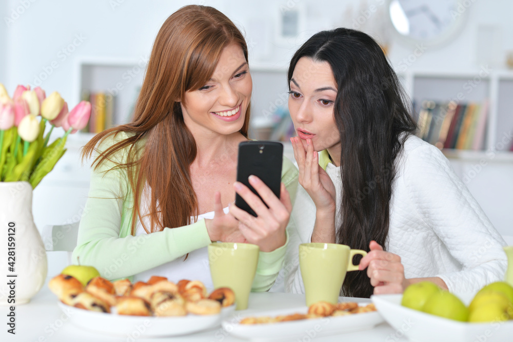 two female friends with modern smartphone