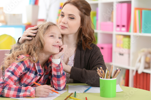 little cute girl with mother drawing