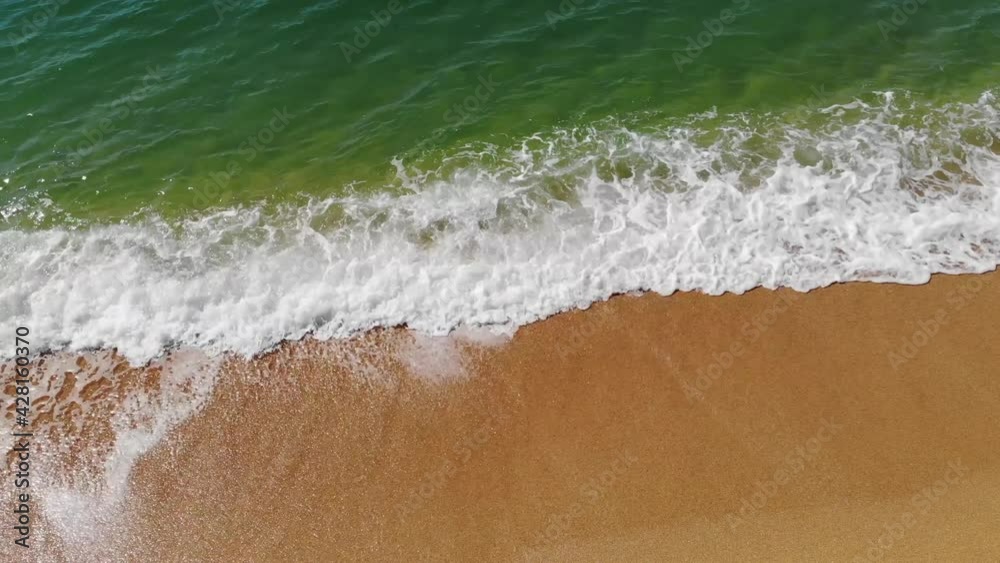 Aerial top view of ocean blue waves crashing on the beach. Sea waves and beautiful sandy beach aerial view shot from a drone. Aerial top view of ocean blue waves crashing on the beach. Sea waves and beautiful sandy beach aerial view shot from a drone.